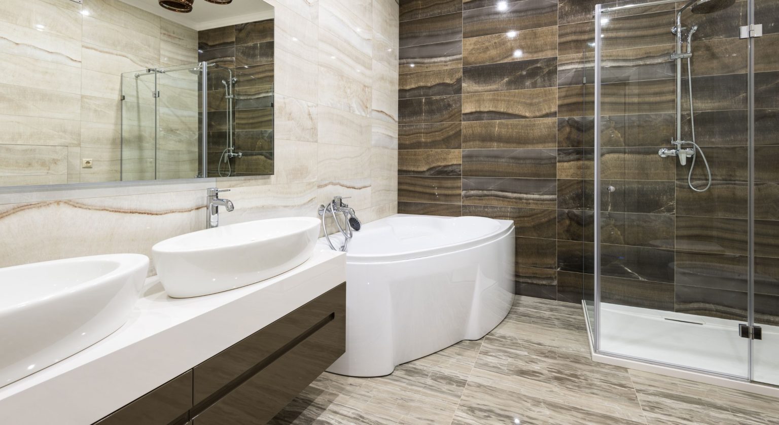 Bathroom renovations Manhattan showcase a modern design with a sleek double sink and freestanding bathtub