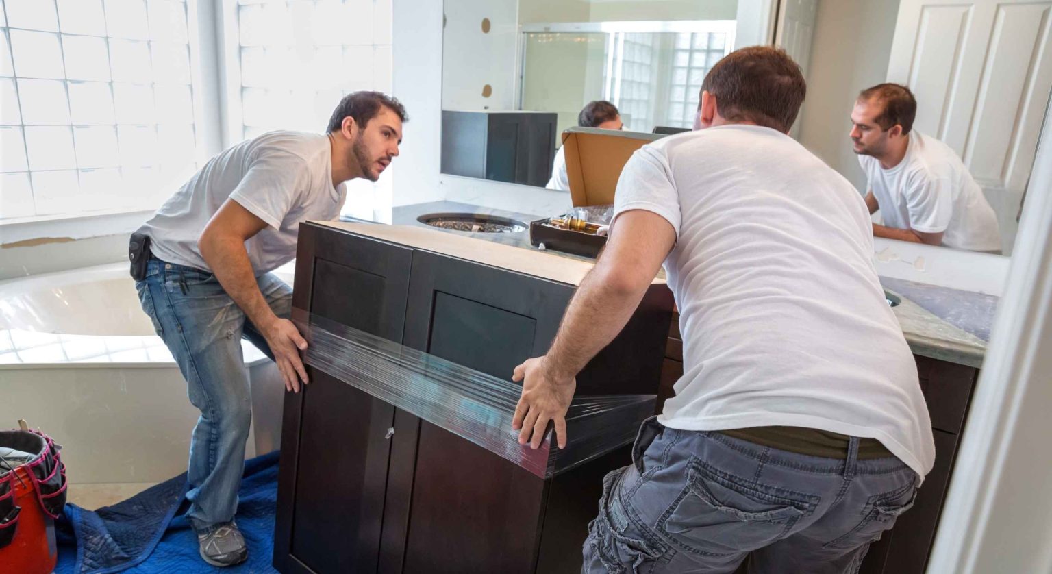 Bathroom renovations Manhattan featuring two men installing a vanity together