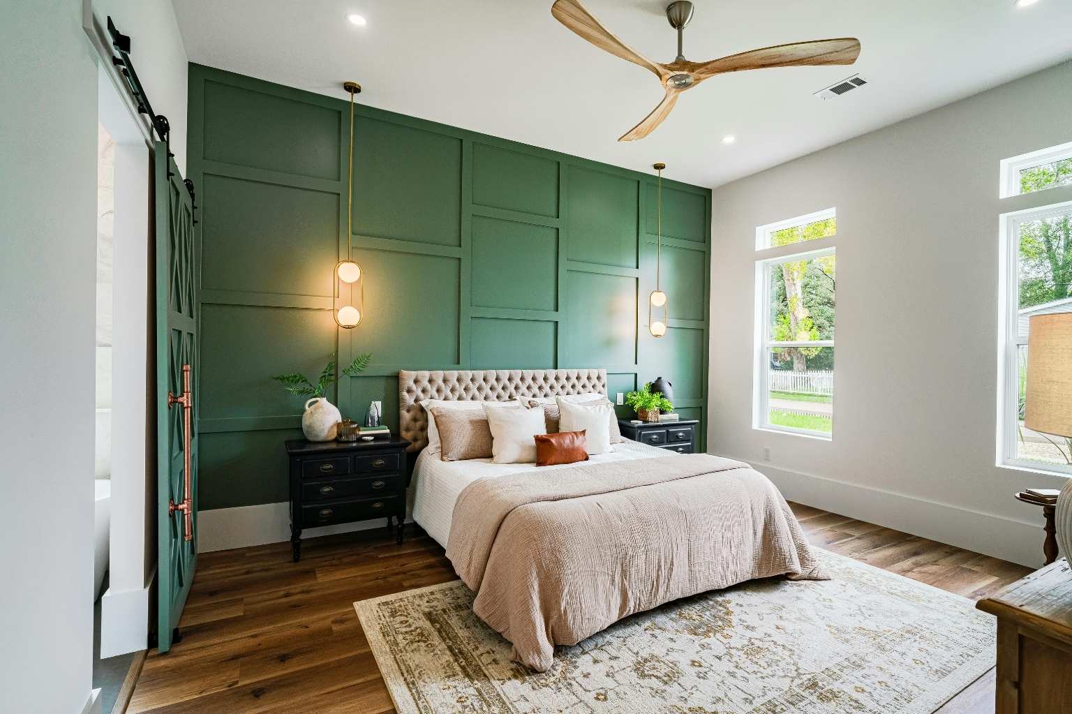 Interior painting enhances the serene bedroom with a stylish green accent wall and elegant furnishings